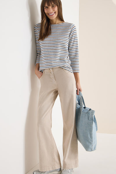 T-shirt à manches longues multicolore de CECIL, rayures horizontales, porté avec un pantalon beige et un sac en jean.