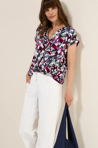 Gekleurd blouse met korte mouwen van CECIL, met abstract patroon en gedragen met een witte broek.
