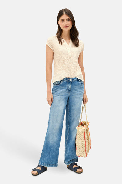 Beige blouse met korte mouwen van CECIL, gedragen met een wijde blauwe jeans en sandalen.