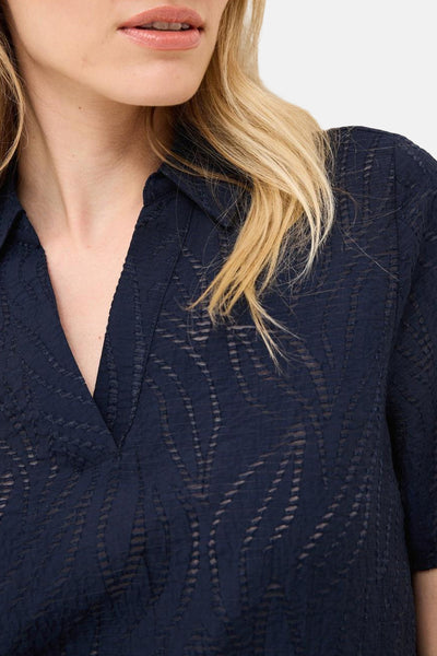 Blouse à manches courtes bleu de CECIL, avec motif à feuilles texturé et col en V.
