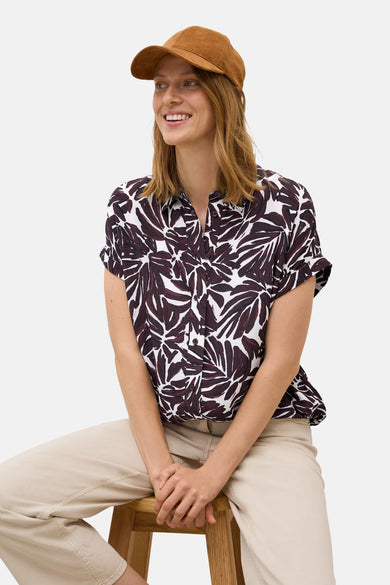 Bordeaux blouse met korte mouwen van CECIL, bladmotief, gedragen met een beige broek en een bruine pet.