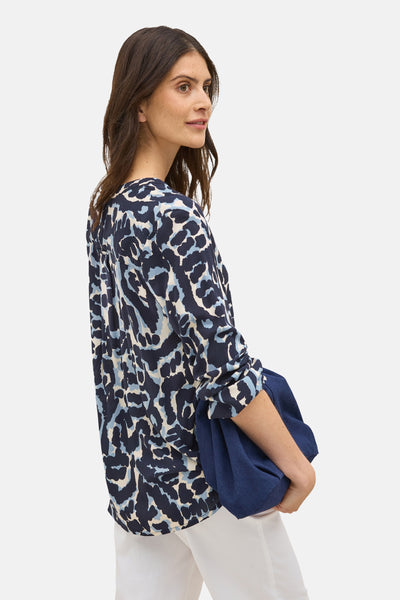 Blauwe blouse met lange mouwen, van CECIL, met luipaardprint en gedragen met een witte broek.