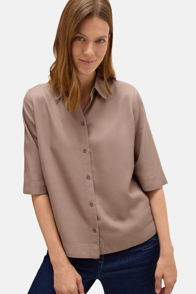 Taupe blouse met korte mouwen van CECIL, met een centrale knoopsluiting en gedragen met een donkerblauwe jeans.