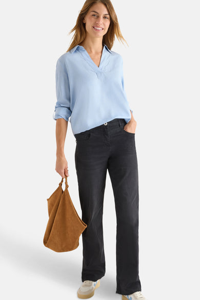 Blauwe blouse met lange mouwen van CECIL, gedragen met een zwarte jeans en een bruine tas.