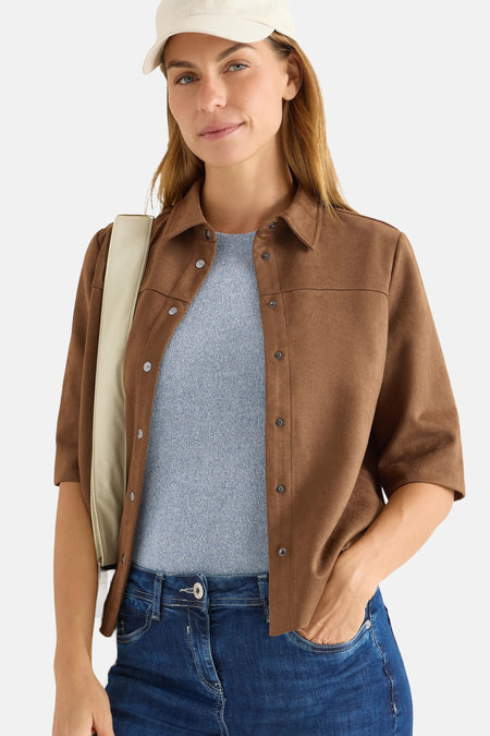 Chemisier à manches longues marron de CECIL, porté sur un pull bleu et un jean, avec une casquette écrue.
