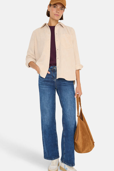 Beige blouse (lange mouwen) van CECIL, gedragen over een bordeaux T-shirt met een spijkerbroek en een handtas.