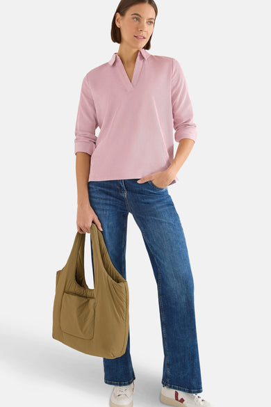 Chemisier à manches longues rose de CECIL, texture plissée, porté avec un jean bleu et un sac.
