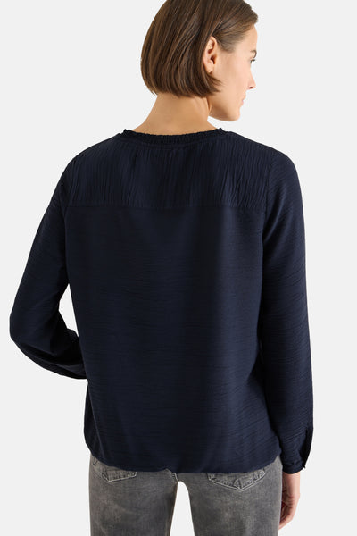 Blouse à manches longues bleue de CECIL, avec texture plissée sur le haut du dos et détails subtils.
