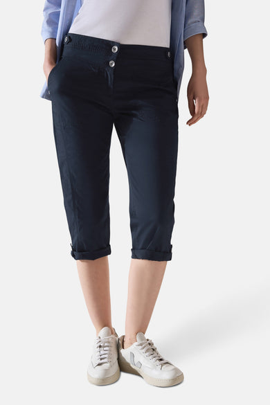 Marineblauwe cargobroek van CECIL, 3/4 model met omslag, gedragen met een wit T-shirt en een blauw overhemd.