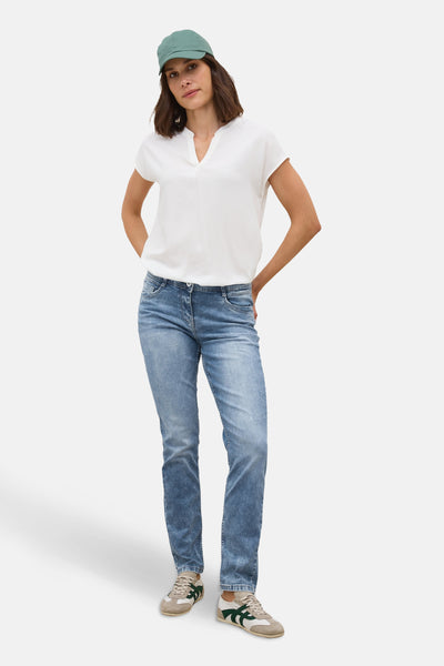 Slim jeans in lichtblauw denim van CECIL, gedragen met een wit T-shirt en retro sneakers.
