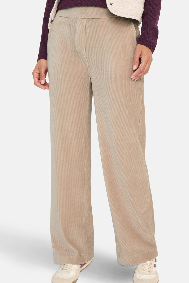 Beige ribfluwelen broek van CECIL, losse pasvorm en wijde pijpen, gedragen met sportschoenen.