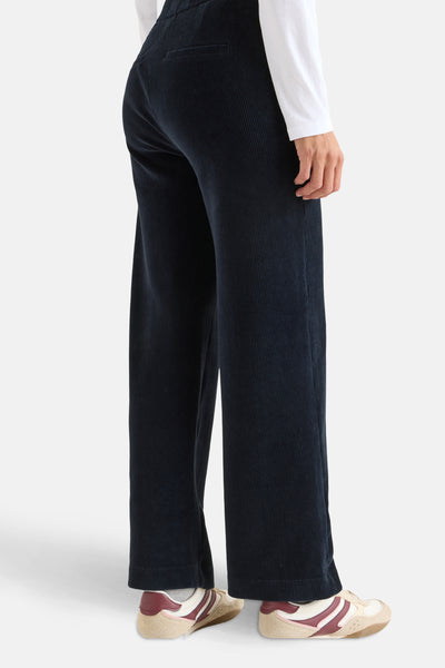 Blauwe corduroy broek van CECIL, losse pasvorm en wijde pijpen, gedragen met een witte top en sneakers.