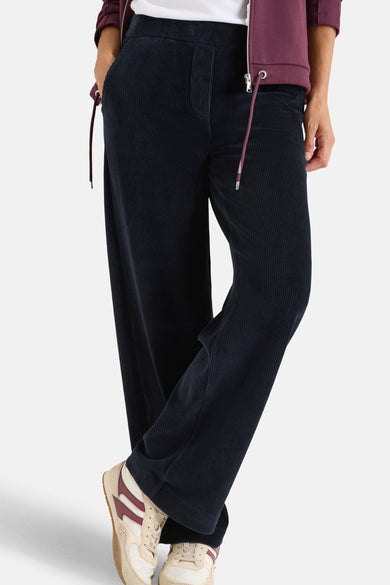 Blauwe corduroy broek van CECIL, losse pasvorm en wijde pijpen, gedragen met sneakers en een witte top.