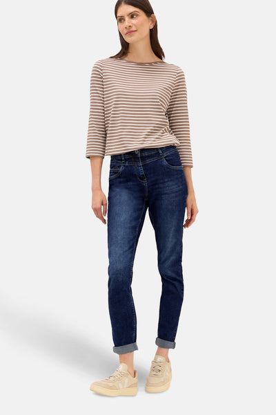 Slim jeans in middendonkerblauw denim van CECIL, gedragen met een gestreept T-shirt en beige schoenen.