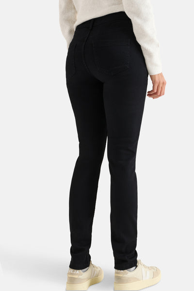 CECIL zwarte denim slim fit jeans, gedragen met een crèmekleurige geribbelde gebreide trui en beige sneakers.