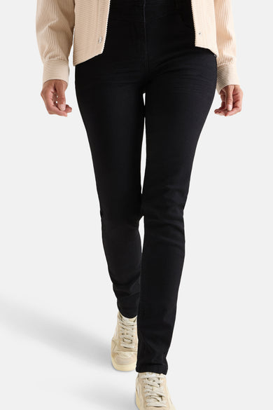 Zwarte denim slim fit jeans van CECIL, gedragen met een crèmekleurig corduroy jasje en beige hoge sneakers.