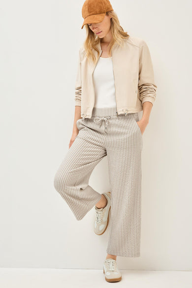 Beige broek van CECIL, met verticale strepen, losse pasvorm, gedragen met een wit T-shirt en een beige jasje.