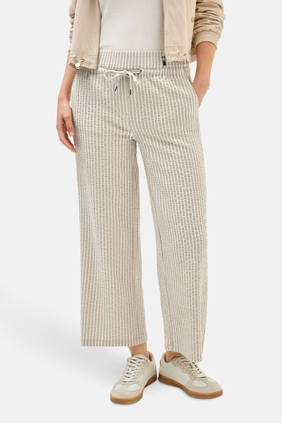 Pantalon beige rayé by CECIL, coupe ample avec cordon de serrage, porté avec une veste beige.
