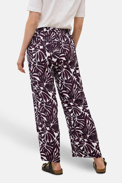 Multikleuren bedrukte broek van Cecil, bladmotief, gedragen met een wit T-shirt en zwarte sandalen.