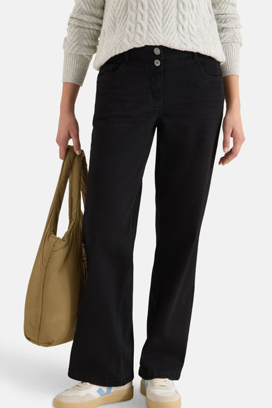 Wijde zwarte denim jeans van CECIL, met knopen aan de taille, gedragen met een kabelgebreide trui en een tote bag.