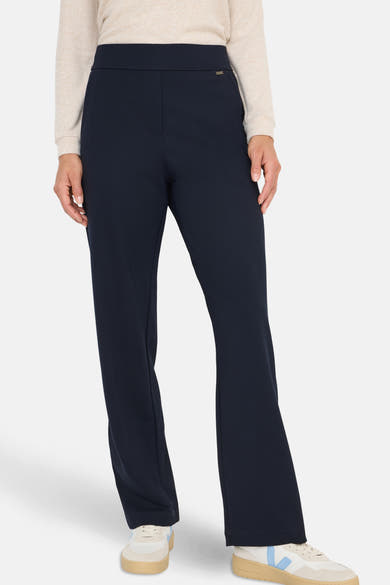 Pantalon de costume bleu de CECIL, porté avec un pull beige et des baskets blanches.