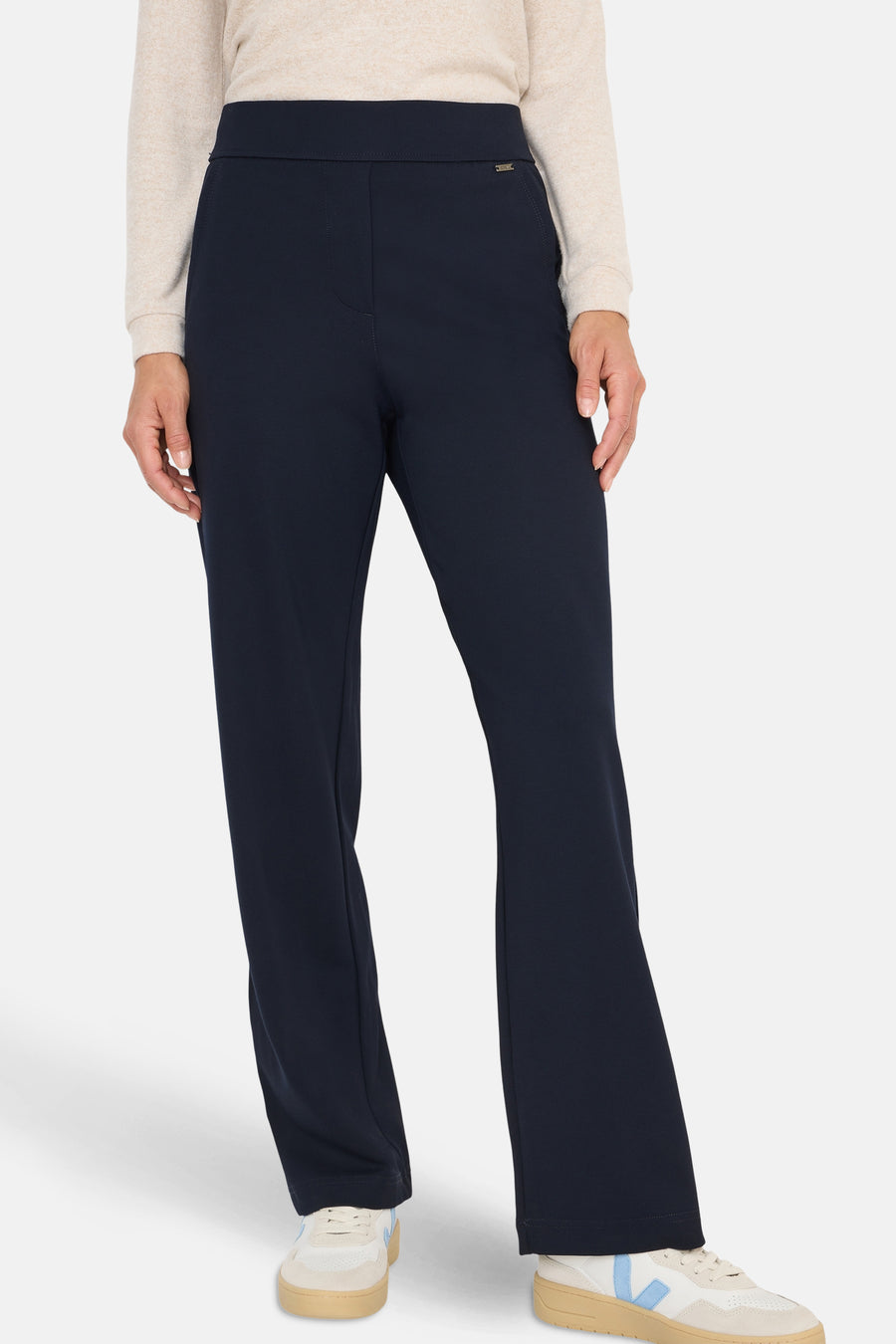 Pantalon de costume bleu de CECIL, porté avec un pull beige et des baskets blanches.