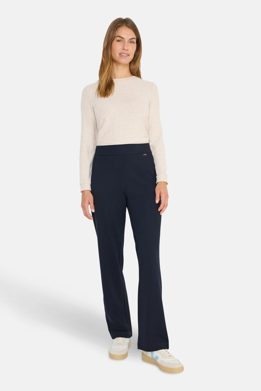 Pantalon de costume bleu marine de CECIL, porté avec un pull beige et des baskets blanches.