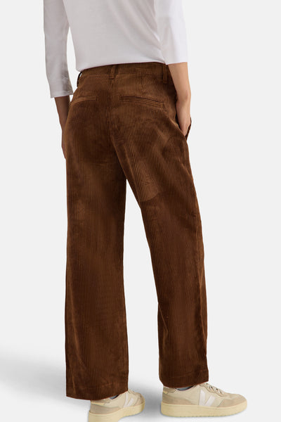 Wijd geruit corduroy broek van CECIL in bruin, van achteren gezien, gedragen met een witte top en beige sneakers.