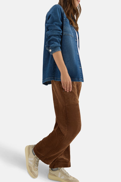 Pantalon brun en velours côtelé de CECIL, porté avec une chemise en jean bleu et des baskets beiges.