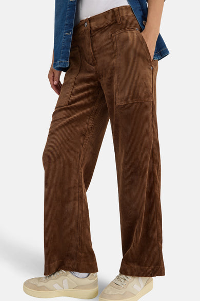 Bruine corduroy broek van CECIL, wijde pasvorm, gedragen met een casual spijkerjasje en beige sneakers.