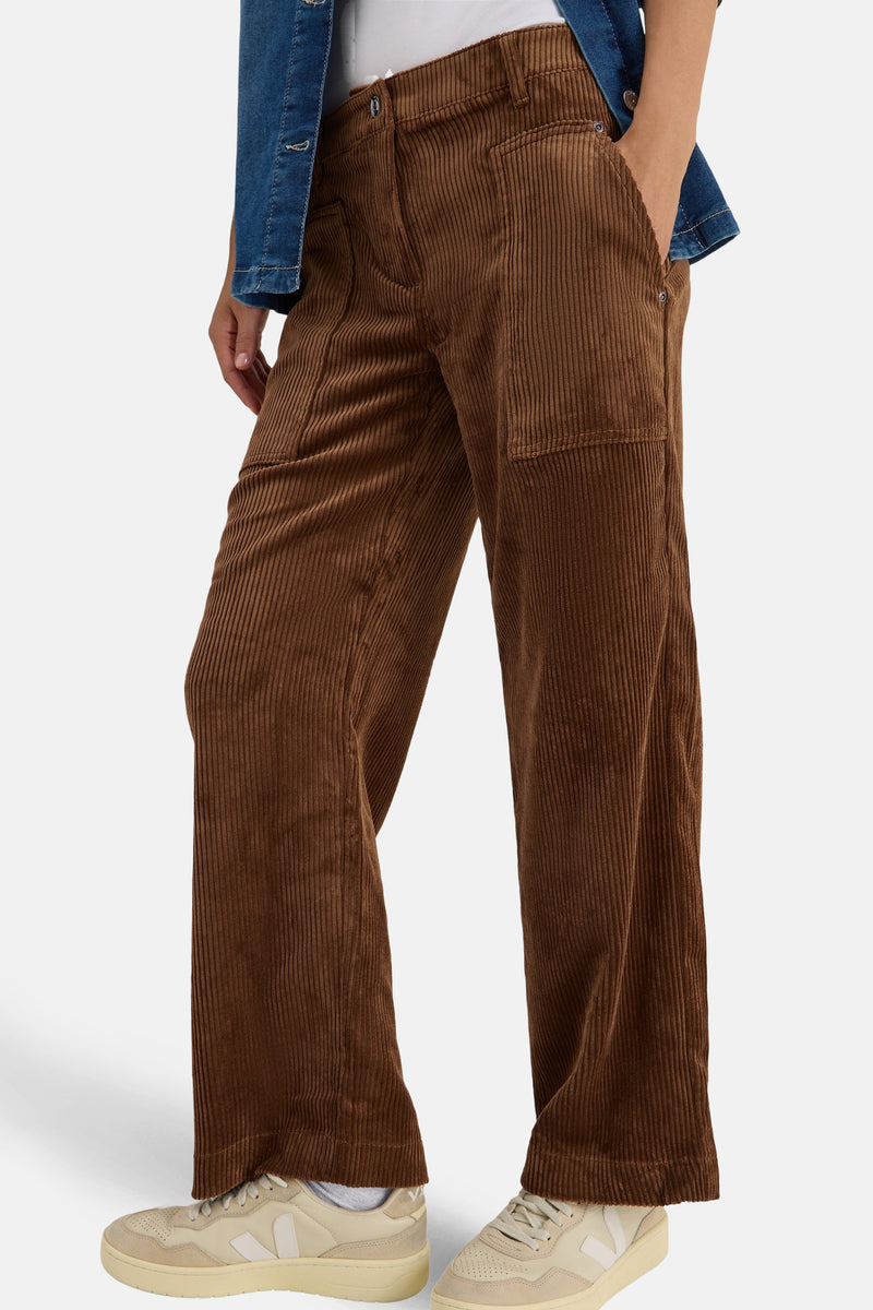 Bruine corduroy broek van CECIL, wijde pasvorm, gedragen met een casual spijkerjasje en beige sneakers.