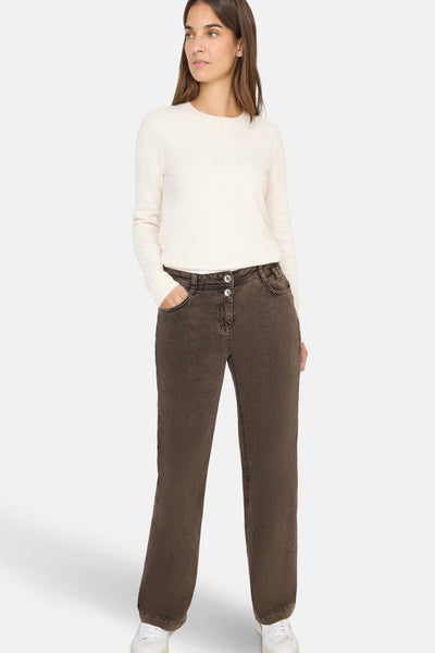 Jean coloré brun de CECIL, coupe droite, avec deux boutons à la taille et porté avec un pull blanc.
