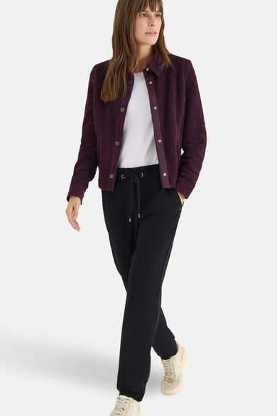 Pantalon de costume noir de CECIL, porté avec un t-shirt blanc et un gilet violet en bouclette.
