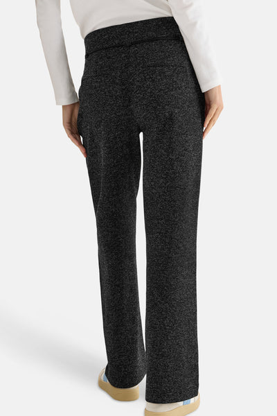 Pantalon noir par CECIL, avec une texture mouchetée, porté avec un haut blanc à manches longues.