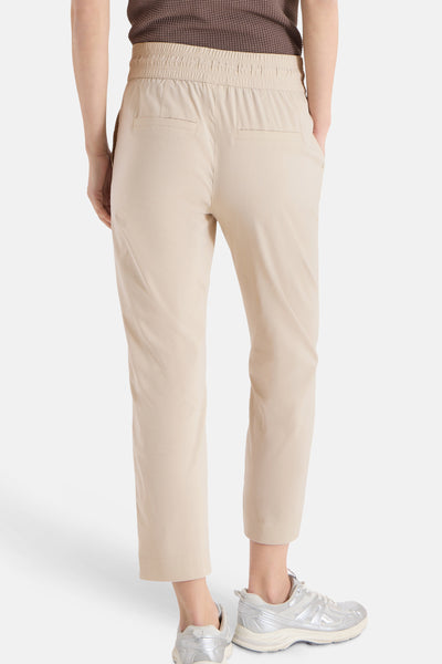 Jogging beige de CECIL, dos, taille élastiquée et poches arrière, porté avec un haut marron et des baskets argentées.