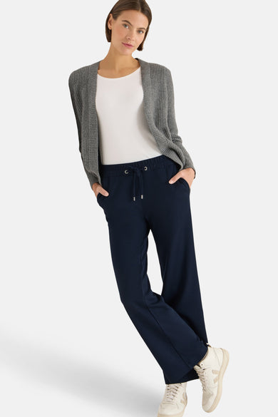 Blauwe broek van CECIL met trekkoord, gedragen met een wit T-shirt en een grijze cardigan.