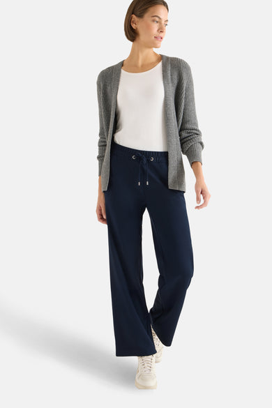 Pantalon bleu de CECIL avec cordon de serrage, porté avec un t-shirt blanc et un cardigan gris.