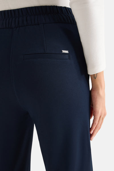 Pantalon bleu marine par CECIL, avec taille élastique et poche passepoilée au dos.
