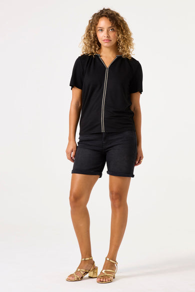 Zwart T-shirt met korte mouwen van GARCIA, met verticale decoratieve detail en gedragen met een zwarte spijkerbroek en gouden sandalen.