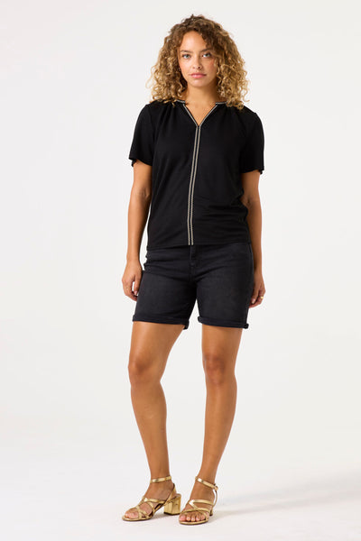 Zwart T-shirt met korte mouwen van GARCIA, met verticale decoratieve detail en gedragen met een zwarte spijkerbroek en gouden sandalen.