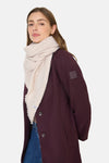 Beige sjaal van CECIL, met decoratieve franjes, gedragen met een bordeauxrode jas, wijde jeans en sneakers.