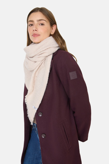 Beige sjaal van CECIL, met decoratieve franjes, gedragen met een bordeauxrode jas, wijde jeans en sneakers.