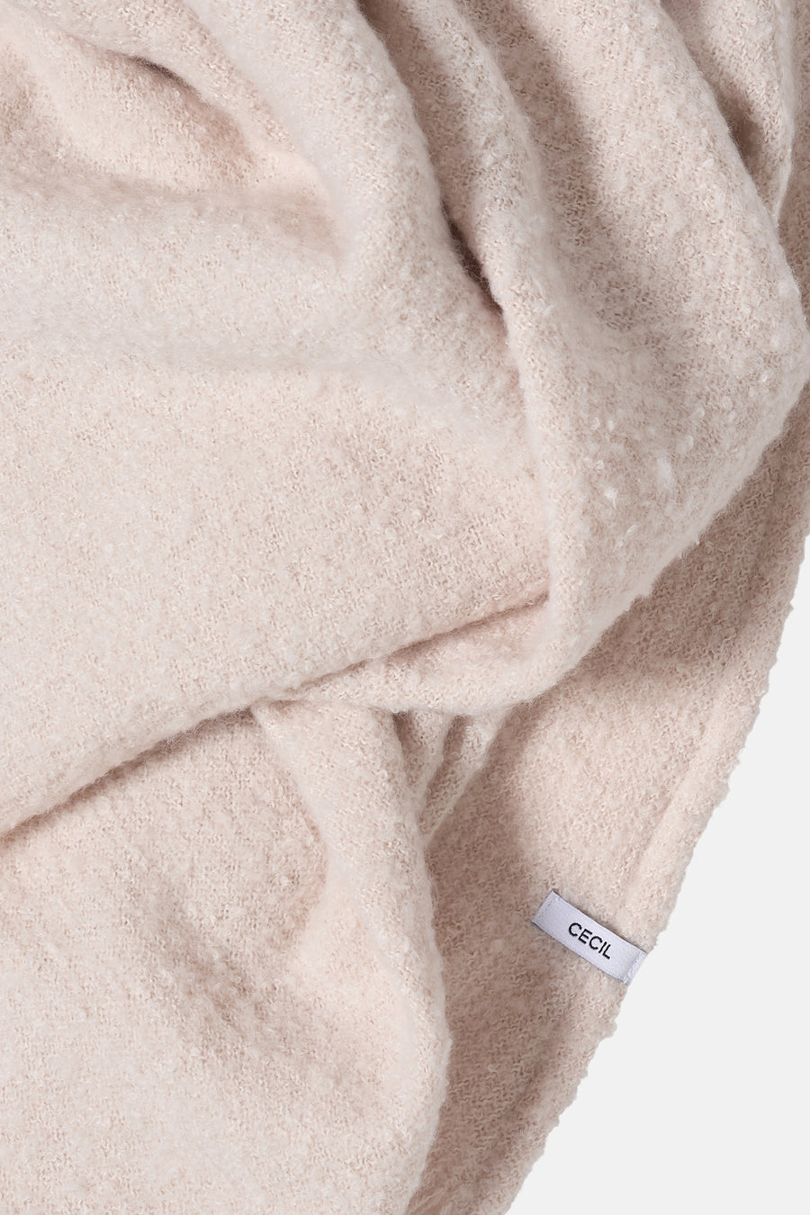 Beige sjaal van zachte breinaard van CECIL, met een pluizige textuur en zichtbaar merklabel.