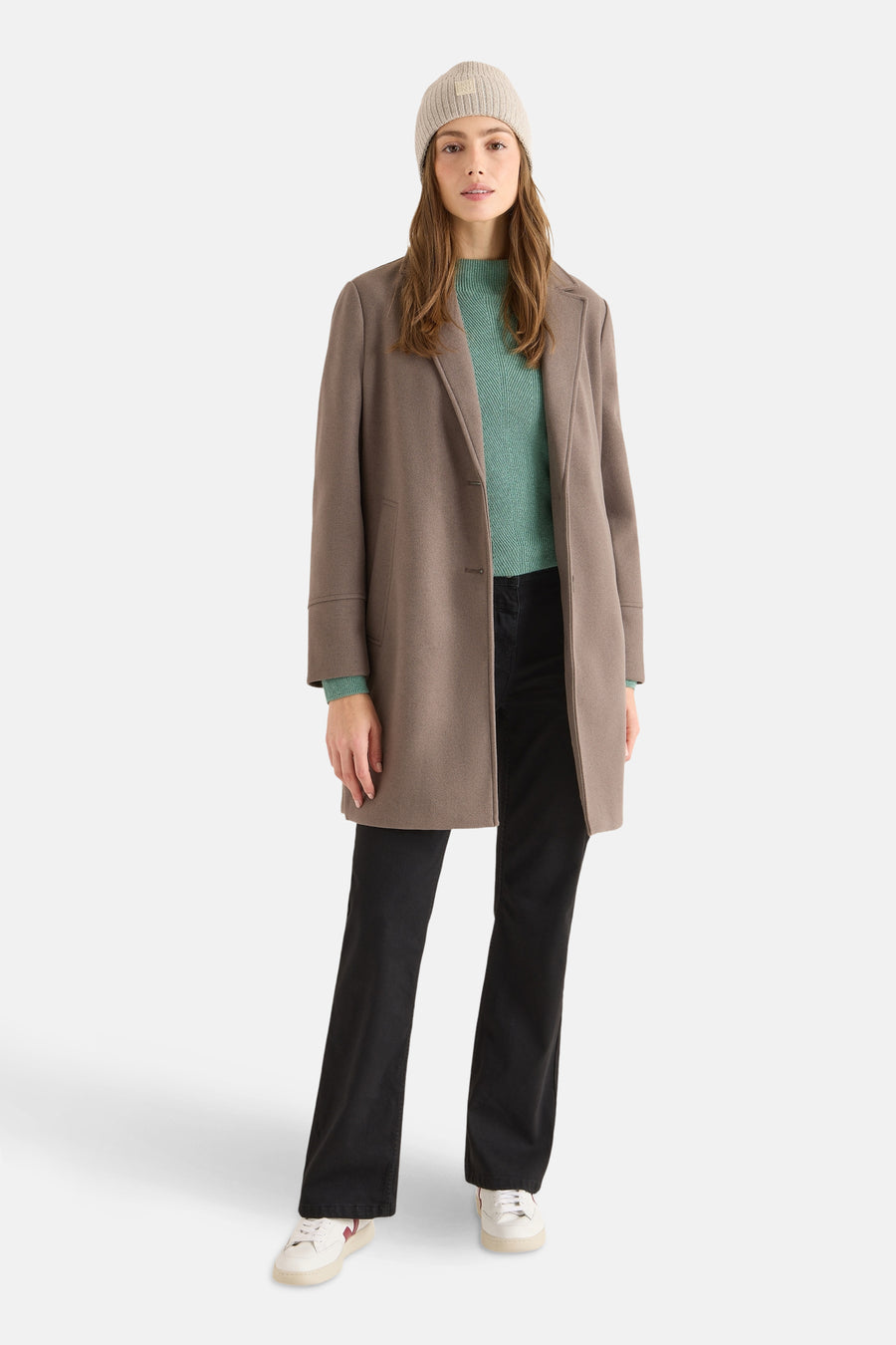 Bonnet beige de CECIL, porté avec un manteau marron et un pull vert d'eau.