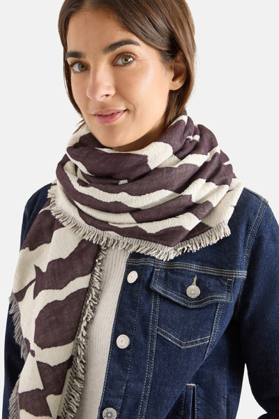 Écharpe multicolore by CECIL, à motif abstrait bicolore, portée avec une veste en jean.