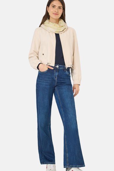 Écharpe argentée de CECIL, accessoire de mode avec un motif subtil et portée avec une veste beige et un jean bleu.