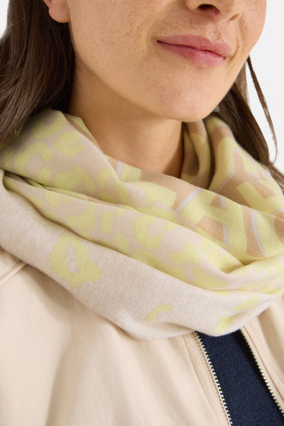 Écharpe argentée de CECIL avec un motif discret et portée autour du cou avec une veste beige.
