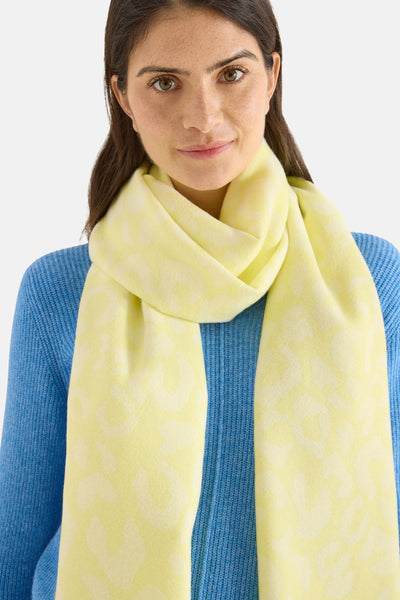 Écharpe jaune de CECIL avec un motif subtil, portée avec un pull bleu.
