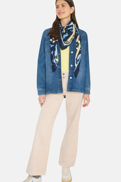Foulard multicolore de CECIL, porté autour du cou avec un motif abstrait et une veste en jean.
