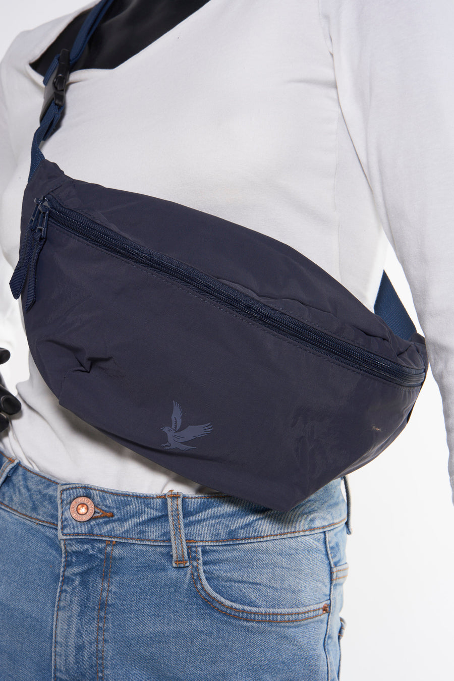 Blauwe heuptas van LYLE & SCOTT gedragen met een spijkerbroek en een witte trui met lange mouwen.